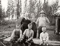 Photo of Louisa and Harry Buzby with children Marian, Ted, Elton and Bob posing outdoors at their homestead.